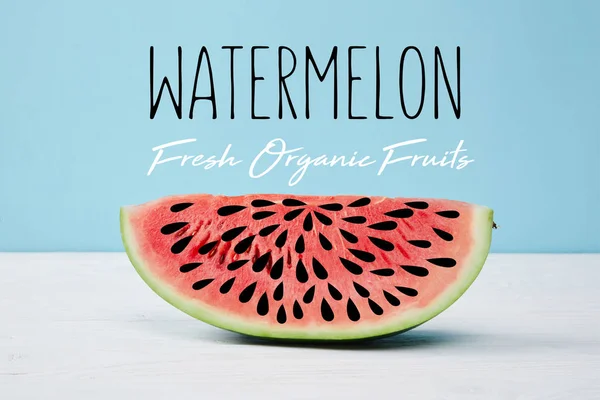 Rote Scheibe mit frischer Wassermelone auf weißer Oberfläche auf blauem Hintergrund, mit dem Schriftzug 