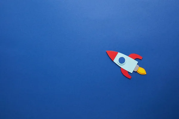 Creative rocket on blue paper background — Stock Photo