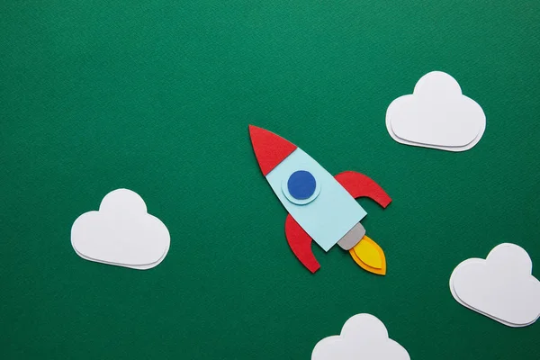 Top view of rocket and clouds on green chalkboard — Stock Photo