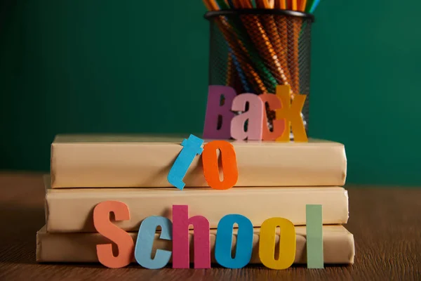 Lettrage retour à l'école avec crayons et livres sur table — Stock Photo