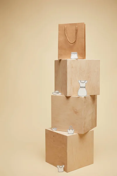 Сумка для покупок і паперовий одяг на дерев'яних кубиках ізольовані на бежевому — стокове фото