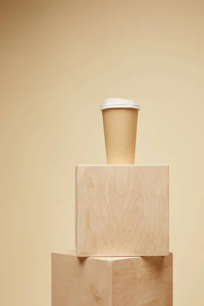 Tasse à café jetable sur cubes en bois isolé sur beige — Photo de stock