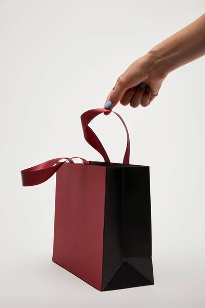 Cropped image of woman touching burgundy shopping bag isolated on white — Stock Photo