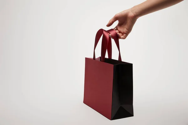 Imagem cortada de menina segurando saco de compras Borgonha isolado no branco — Fotografia de Stock