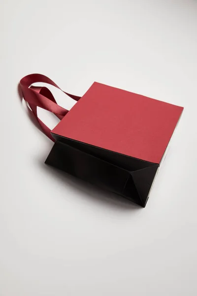 One burgundy shopping bag on white surface — Stock Photo