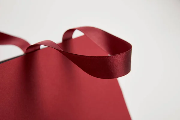Close up of handle of burgundy shopping bag isolated on white — Stock Photo