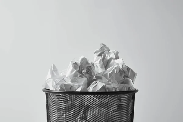 Close-up shot of office trash bin with crumpled papers isolated on white — Stock Photo