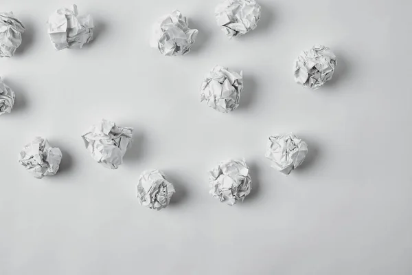 Draufsicht auf verschüttete zerknüllte Papiere auf weißer Oberfläche — Stockfoto
