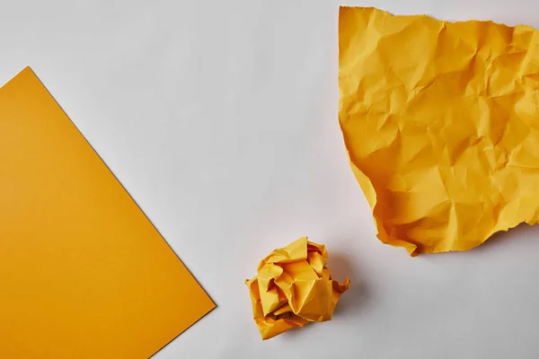 Vista superior de papeles amarillos sobre superficie blanca - foto de stock