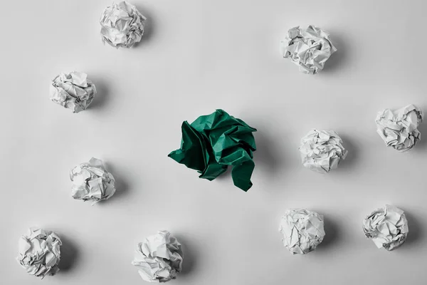 Top view of green and white crumpled papers on white surface — Stock Photo