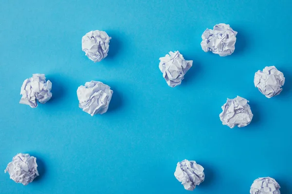 Top view of crumpled papers on blue surface — Stock Photo