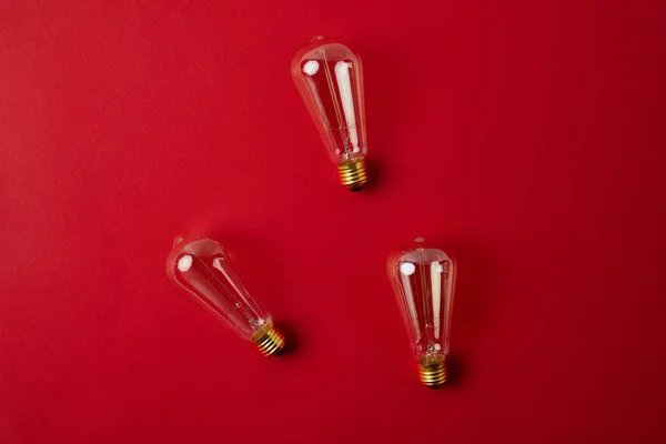 Vista superior de lâmpadas incandescentes vintage na mesa vermelha — Fotografia de Stock