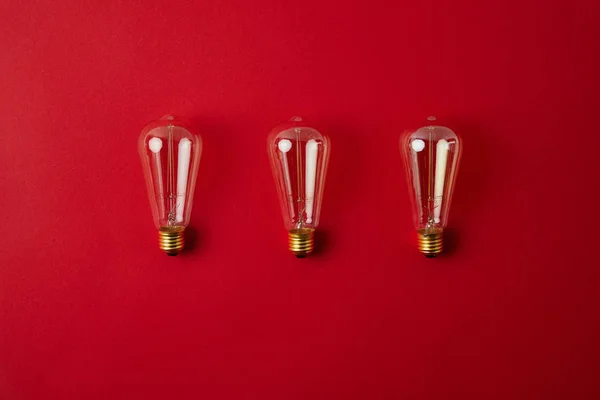 Vue de dessus de la rangée de lampes à incandescence vintage sur le dessus de table rouge — Photo de stock