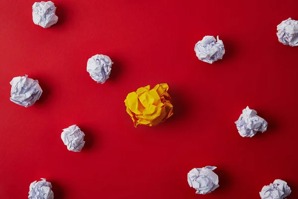 Vue de dessus des papiers blancs et jaunes froissés sur la surface rouge — Photo de stock