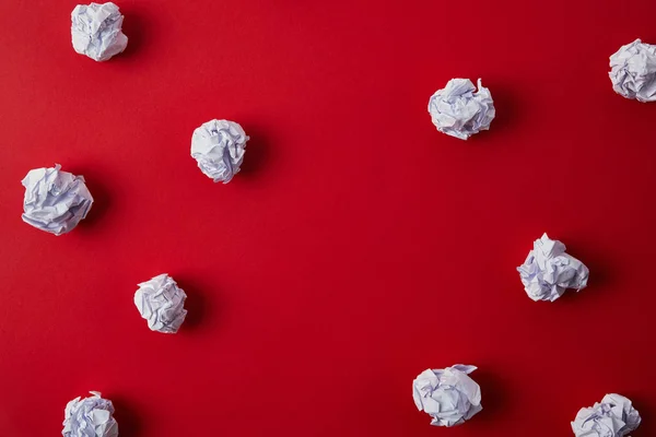 Vue de dessus des papiers blancs froissés sur la surface rouge — Photo de stock