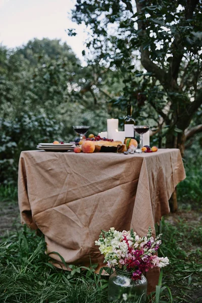 Serviertisch im Garten, Blumenstrauß auf Gras — Stockfoto