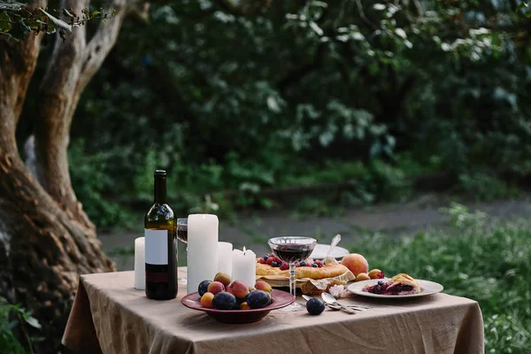 Served table for romantic dinner in garden — Stock Photo