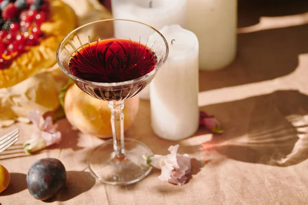 Wineglass and candles on table in garden — Stock Photo