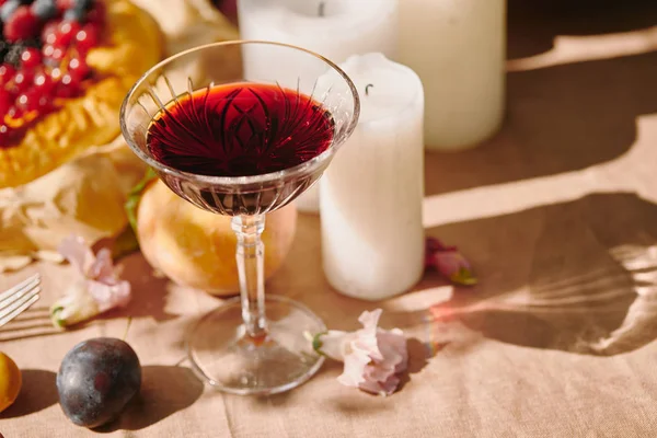 Vino y velas en la mesa en el jardín - foto de stock