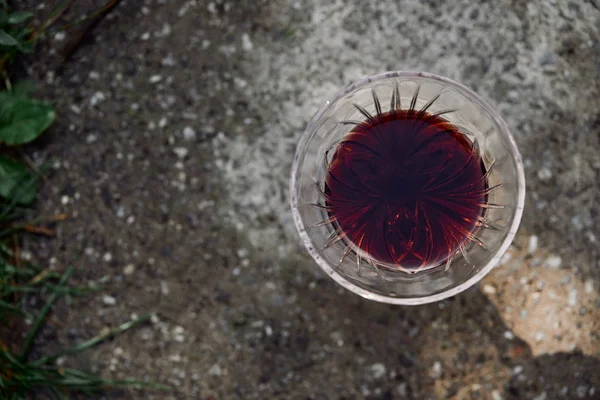 Vue de dessus d'un verre de vin rouge sur la route dans le jardin — Photo de stock