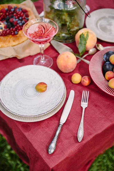 Pratos, garfo e faca na mesa no jardim — Fotografia de Stock