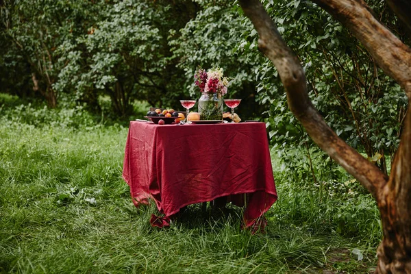 Mesa servida con comida y bebidas en el jardín — Stock Photo