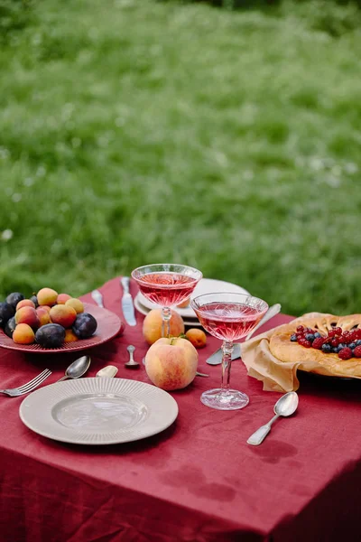 Copos de vinho, frutas e bagas torta na mesa no jardim — Fotografia de Stock