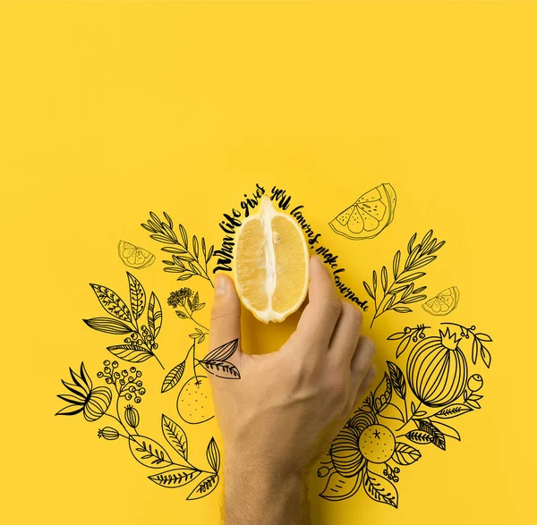 Чоловік тримає половину лимона ізольовано на жовтому з написом 
