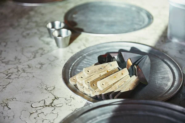 Cake servers lying on metal tray on marble table at restaurant kitchen — Stock Photo