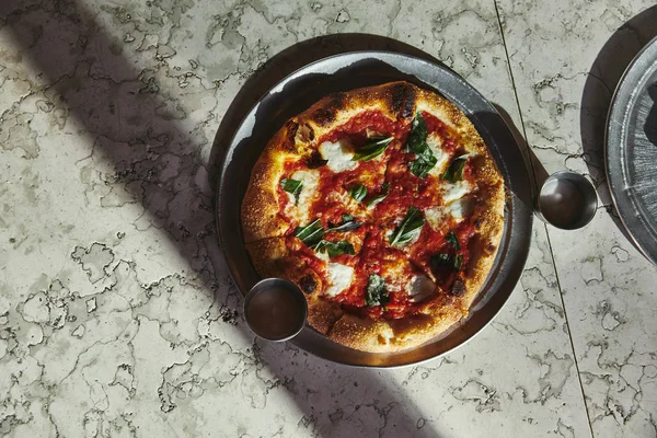 Vista superior de la deliciosa pizza margherita sobre mesa de mármol - foto de stock