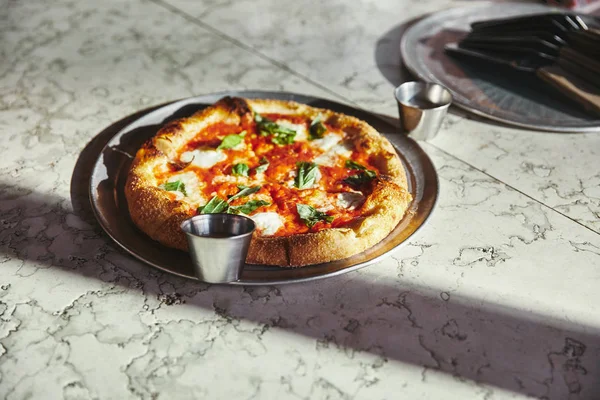 Close-up shot of freshly baked pizza margherita on marble tabletop — Stock Photo