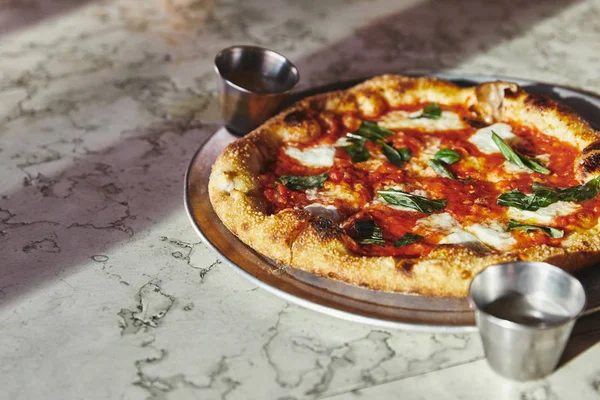 Close-up de deliciosa margherita pizza na bandeja em mesa de mármore — Fotografia de Stock
