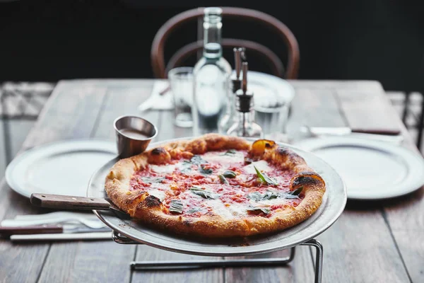 Close-up shot of freshly baked pizza margherita on metal tray at restaurant — Stock Photo