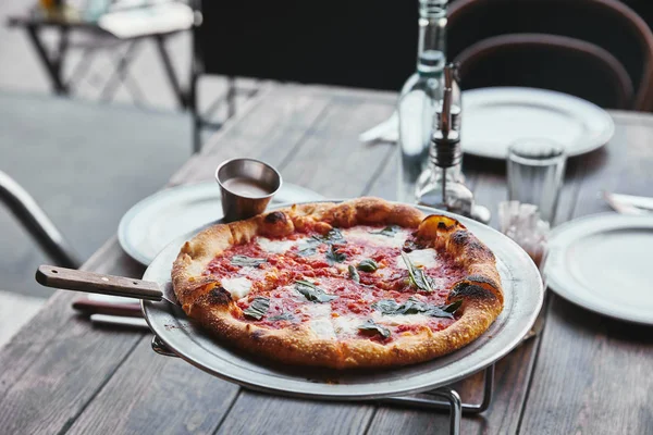Close-up shot of delicious pizza margherita on metal tray at restaurant — Stock Photo