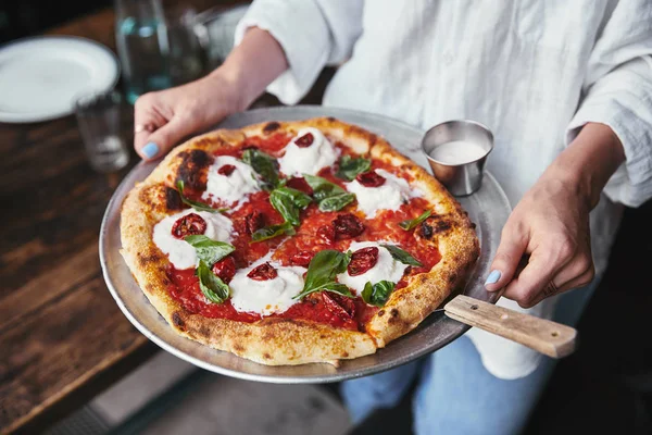 Plan recadré de femme portant une assiette avec de délicieuses pizzas — Photo de stock