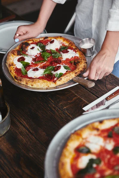 Tiro cortado de mulher carregando prato com deliciosa pizza — Fotografia de Stock