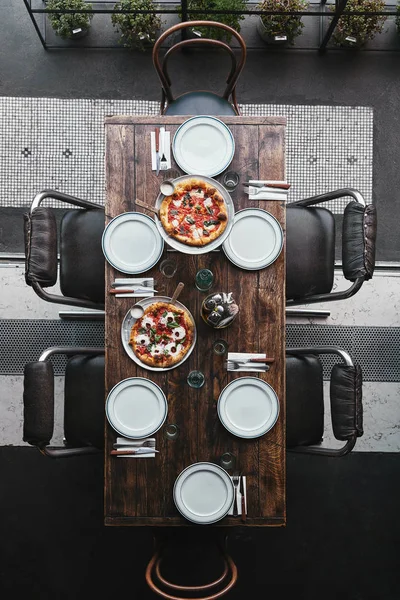 Vue de dessus de différentes pizzas sur plateaux et table au restaurant — Photo de stock