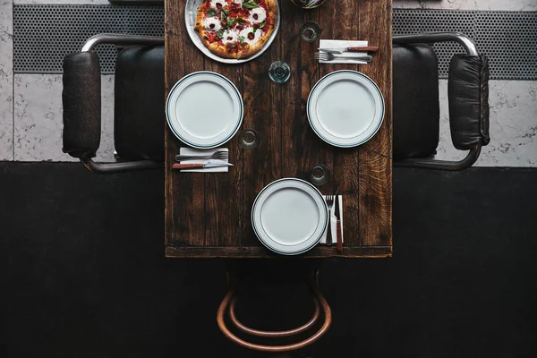 Vista superior de la pizza margherita en bandeja y mesa en el restaurante - foto de stock