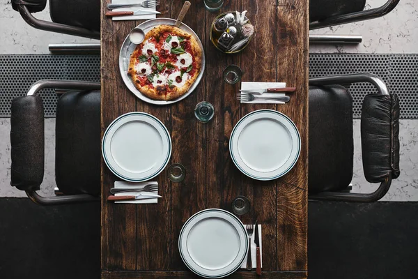 Vista superior da deliciosa pizza na bandeja e mesa no restaurante — Fotografia de Stock