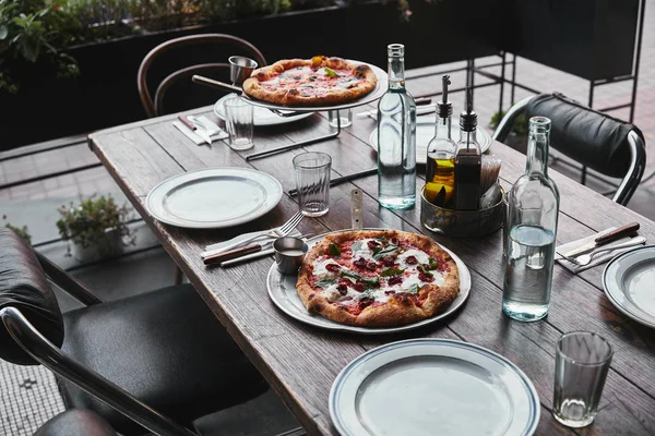 Различные свежеиспеченные пиццы на подносах в ресторане — стоковое фото