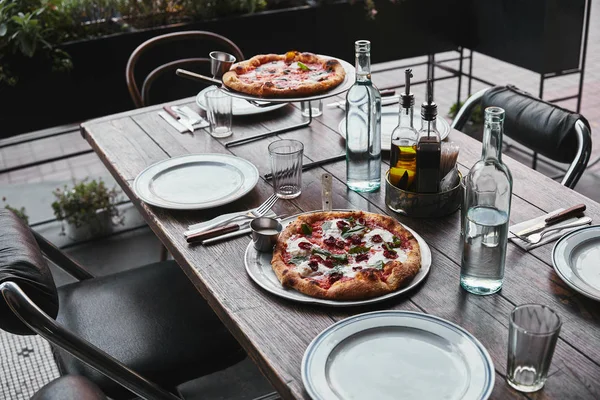 Diferente pizza recién horneada en bandejas en el restaurante - foto de stock