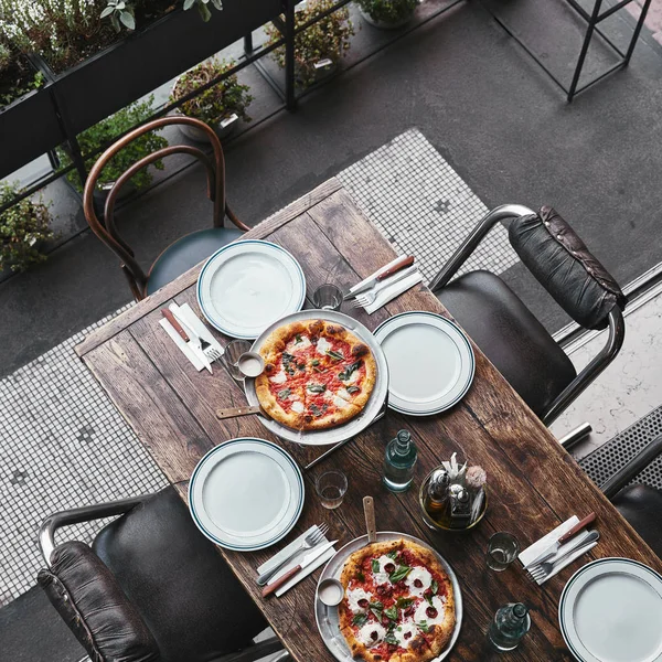 Blick von oben auf verschiedene leckere Pizza auf Tabletts im Restaurant — Stockfoto