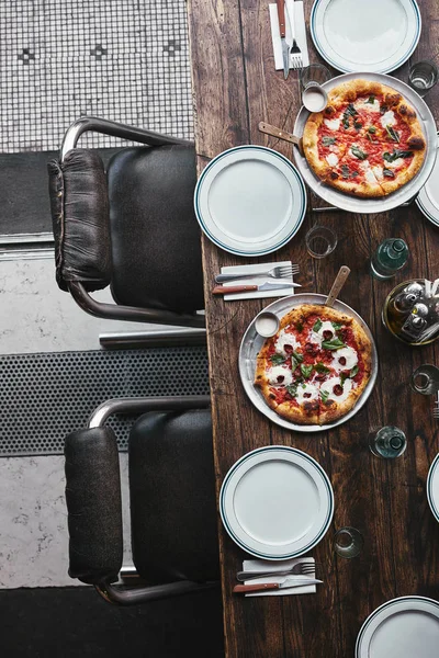 Vue de dessus de diverses délicieuses pizzas sur des plateaux au restaurant — Photo de stock
