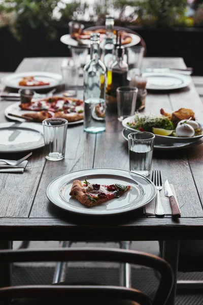 Leckere Pizza und Salat auf dem Tisch im modernen Restaurant — Stockfoto