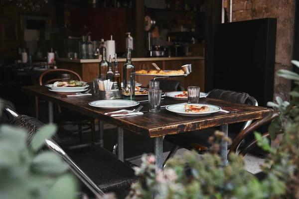 Deliciosa comida italiana en la mesa rústica en el restaurante moderno - foto de stock