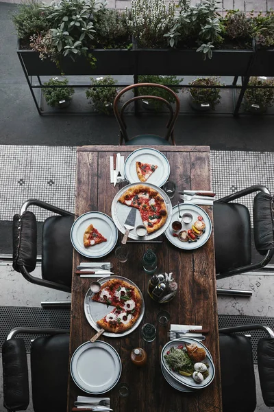 Vista superior de la sabrosa comida en la mesa rústica en el restaurante - foto de stock