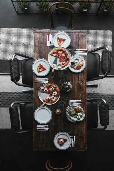 Vista superior de deliciosa comida en mesa rústica en el restaurante - foto de stock