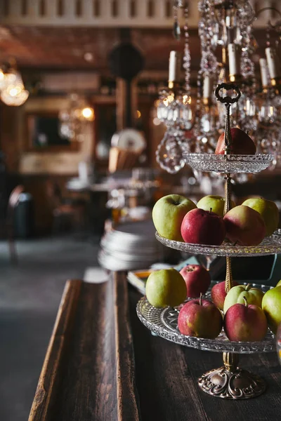 Close-up shot of vintage stand with ripe apples standing on bar counter at restaurant — Stock Photo