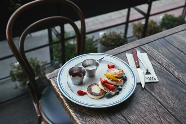 Crêpes caillées savoureuses avec bols de trempettes et couverts sur table en bois — Photo de stock