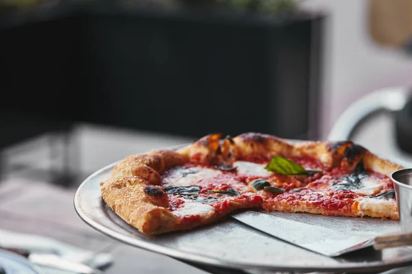 Close-up shot of tasty pizza on tray and on blurred background — Stock Photo